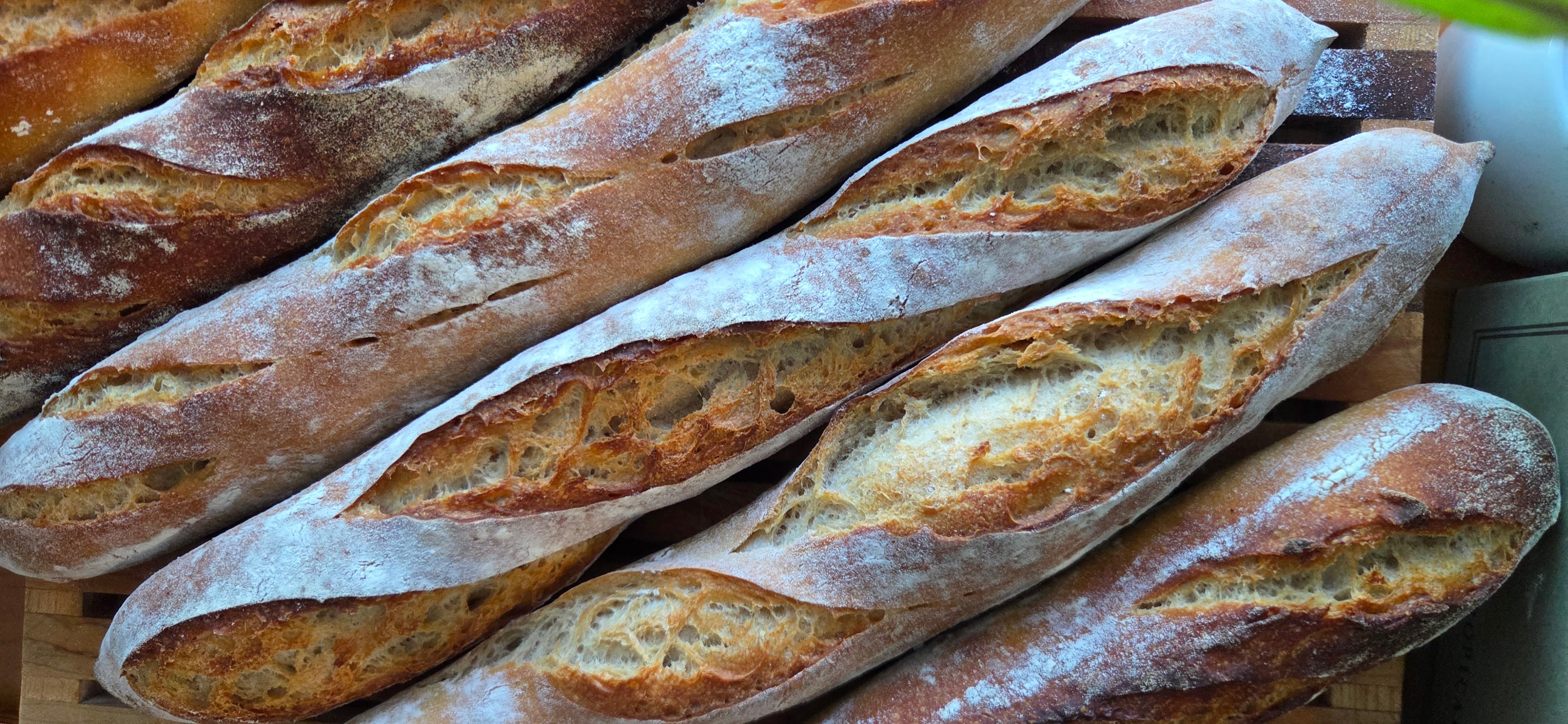 Freshly baked sourdough baguettes arranged on a wooden board