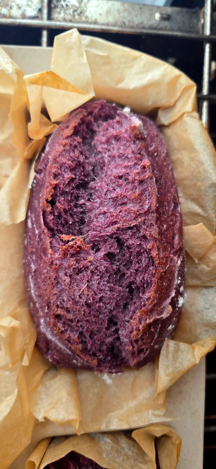 A purple Peruvian corn sourdough loaf with an open scored crust